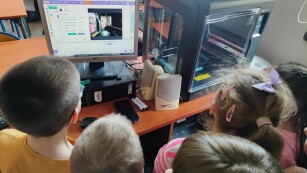 Dzieci obserwują wydruk w programie komputerowym