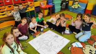 dzieci układają z elementów godło Polski na dywanie